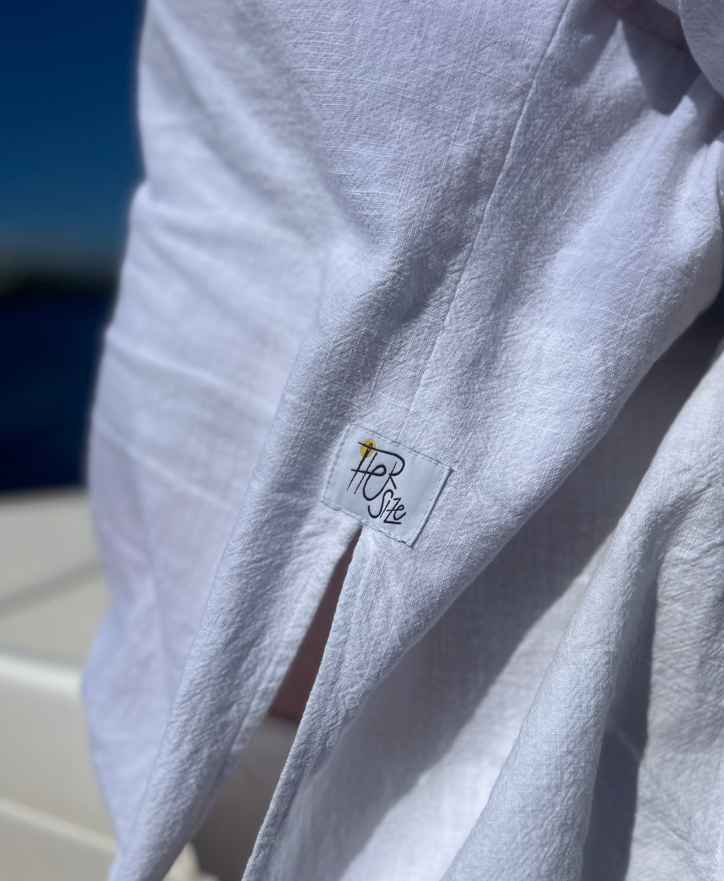 Detail bielej ľanovej oversize košele.